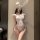 Woman wearing white lace bodysuit with bunny ears, featuring sheer vintage-inspired design and open-crotch detail for sensual...