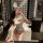 Woman wearing white lace bodysuit with bunny ears, taking mirror selfie in bathroom.