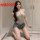 Woman kneeling in sensual lace bodysuit with denim shorts, showcasing plus size erotic lingerie set for women.