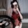 Woman wearing red sensual lace bodysuit with sheer mesh, open-crotch design, and provocative uniform style, holding phone.