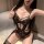 Woman wearing black lace bodysuit with floral patterns and strappy design, posing seductively on white rug. sensual lace body...