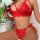 Woman wearing red lace lingerie set with sheer thong and bondage-style straps.