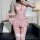 Pink lace lingerie set with boned corset top, ruffled bottoms, and garter straps—sensual, alluring sleepwear for women.