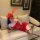 A woman lounges on a couch wearing a sensual lace off-shoulder corset dress with a provocative sheer cutout design, perfect f...