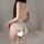 Woman wearing white lace open-crotch bodysuit with sheer back and ruffled hem, styled as sensual sleepwear lingerie.