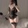 Woman wearing black lace open-crotch bodysuit with sheer panels, thigh-high stockings, and feather accessory; sensual sleepwe...