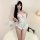 Woman modeling white lace open-crotch bodysuit with sheer cutouts, ruffled hem, and floral headpiece—sensual lace open-crotch...