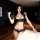 Woman wearing black lace sleep set with pink bows, featuring bralette and matching panties for small bust.
