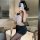 Woman in black lace sleepwear set with sheer top and shorts, posing by bathtub for romantic bedroom or date night look.