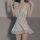 Woman wearing white lace-trimmed nightgown with deep v-neck and ruffled sleeves, part of sensual sleepwear set.