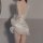 Woman wearing white lace sleepwear set with ruffled hem and open back design.