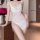 Woman wearing white sheer mesh slip dress with lace trim and cowl neckline, featuring side slit and delicate straps.