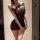 Woman wearing a sheer black one-shoulder lingerie set, featuring a form-fitting bodice and mini skirt with horizontal stripes...