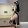 Woman in black high-slit nun costume with lace trim, holding candle—sensual cosplay lingerie set for women.