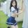 Woman in sensual secretarial bodysuit with airline-style skirt, posing outdoors by a tent.