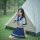 Woman in navy and white sailor-style skirt set kneeling by tent outdoors, showcasing the sensual secretarial bodysuit - airli...