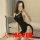 Woman wearing a black backless chain sleep dress, posing on a couch. seductive bodycon nightclub outfit with lingerie-inspire...