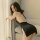 Woman wearing a black backless chain sleep dress, featuring a bodycon fit and lingerie-inspired design.