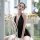 A woman wearing a black backless lace bodysuit with deep v-neck, perfect for plus-size sleepwear sets and seductive nightwear...