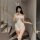 Woman in white bunny costume with lace details, posing on stairs.