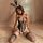 Woman in black bunny girl bodysuit with sheer mesh, cut-outs, and lace trim, paired with fishnet stockings and bunny ears hea...