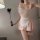 Woman modeling a pink lace sheer maid outfit with ruffles, holding a feather wand; part of the sexy bunny girl costume set fo...