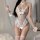 Woman wearing white sheer lace bunny lingerie set with ruffles, pom-poms, and heart charm for valentines day or christmas.