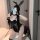 Woman in black bunny ears and flirty ruffle bodysuit with sheer lace, posing seductively in lingerie set.