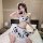 Woman wearing a sexy cow costume lingerie set with playful open-crotch design and cute matching sleepwear, posing on a bed.