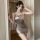 Woman wearing sexy deep v backless bodycon bandage dress, shimmering gold mini outfit for nightclub or lingerie occasions.
