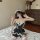 Woman in black lace maid lingerie dress with white trim, sitting on bed. sweet cosplay sleepwear, plus size temptation outfit...