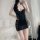 Woman wearing black deep v lace mesh sleep dress with ruffled sheer sides and open-crotch design, posing in bedroom.
