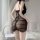 Woman wearing black deep v lace mesh sleep dress with ruffled sheer design and open-crotch detail, back view in bedroom.