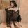 Woman wearing black lace babydoll and garter belt set, sheer mesh sleepwear with deep v neckline.