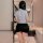 Woman in tight police officer costume with short skirt and blouse, posing in modern bathroom for role play or cosplay.