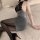 Woman in sexy flight attendant costume with black lace top, sparkly gray skirt, sheer tights, and high heels for role play.