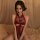 Woman wearing red lace open-crotch bodysuit with halter neckline and floral embroidery, styled as seductive sleepwear lingeri...