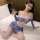 Woman wearing blue and white sexy football cheerleader costume set with detachable skirt, posing on bed for cosplay role play...