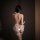 Woman wearing sexy halter lace open-crotch bare-butt bodysuit set – romantic pure-yet-sensual lingerie with heart detail.