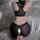 Woman wearing black ice silk open-crotch yoga pants set with zipper-design lingerie leggings, shown from back on fluffy white...