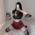 Woman posing in sexy jk style lingerie set with red plaid skirt, black crop top, and striped thigh-highs.