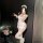Woman posing in sexy lace backless maid costume with sheer apron sleep dress, bare-back design and cheeky cutout detail.