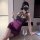 Woman in purple lace bodycon mini dress with built-in pads, posing elegantly at table with wine glass.