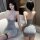 Woman modeling sexy lace halter bodysuit with glitter mini skirt set, front and back view on sofa.
