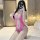Woman in pink lace bodysuit with open-crotch design, sheer mesh sleepwear set, posing on bed.