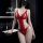 Woman wearing red lace bodysuit with sheer cut-outs, posing in a modern bathroom. seductive lingerie set for adults.