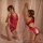 Woman modeling red sexy lace bodysuit, sheer see-through lingerie with no-remove design, posed seductively against soft curta...