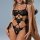 Woman wearing black lace bodysuit with sheer mesh and crisscross straps, strapless erotic lingerie design.