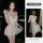 Woman wearing a sexy lace chemise sleepwear set with sheer mesh, high slit, and matching lingerie.