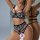 Woman modeling black floral lace lingerie set with push-up bra and open-crotch panties, elegant two-piece design.